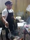 All dishes are cooking in woks and this cook makes more than 300 dishes per night.